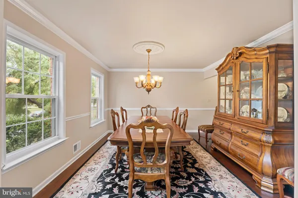 a view of a dining room with furniture wooden floor and a chandelier