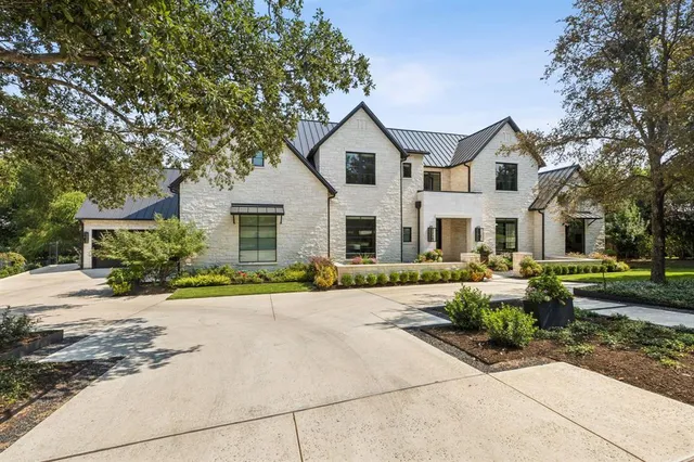 a front view of a house with a yard and potted plants