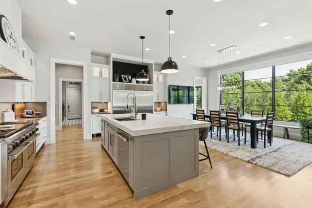 a kitchen with stainless steel appliances granite countertop a stove and a large window