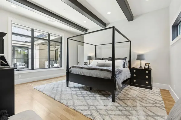 a bedroom with a bed and large windows