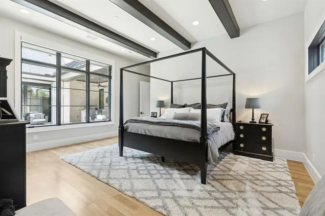 a bedroom with a bed and large windows