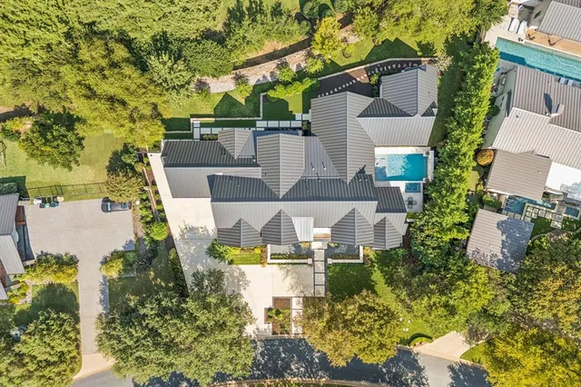 an aerial view of a house with swimming pool and garden