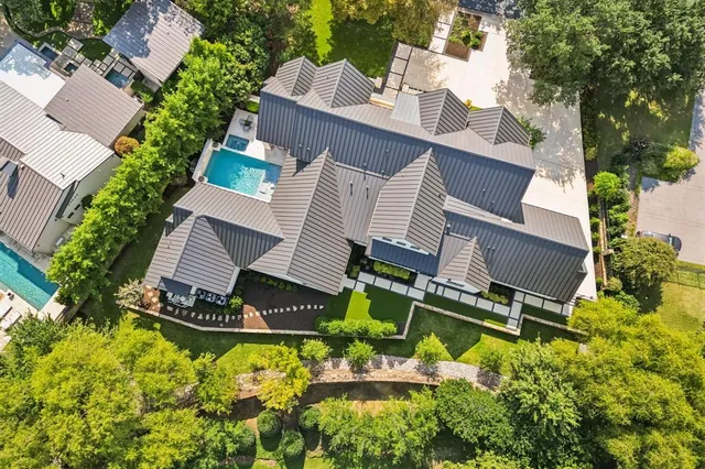 an aerial view of a house with swimming pool and garden
