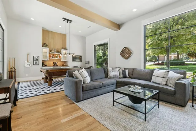 a living room with furniture potted plant and a large window