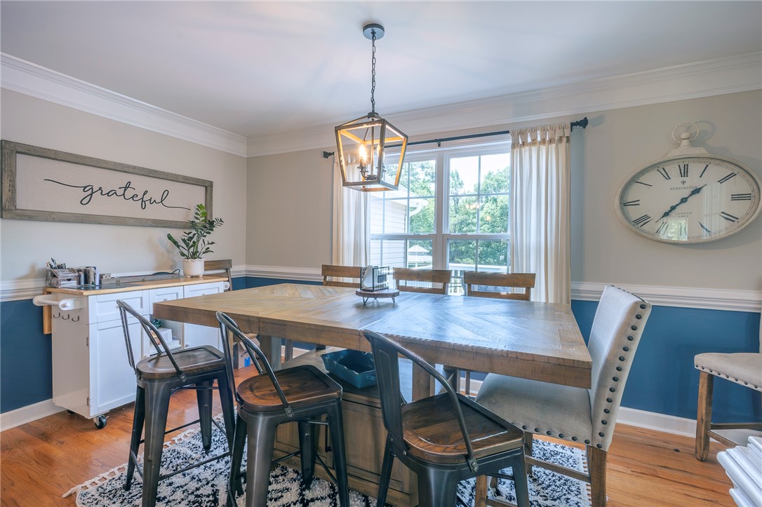 861 North Old Pendleton Road Liberty, SC 29657 - Photo 14 of 45 A well-lit dining area features crown molding, hardwood flooring, and a decorative pendant light.