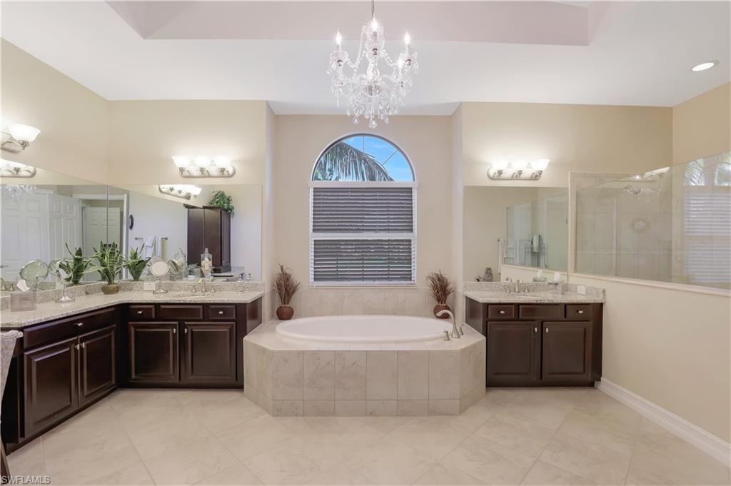 Undisclosed Address Naples, FL 34120 - Photo 12 of 33 a spacious bathroom with a tub sink and mirror