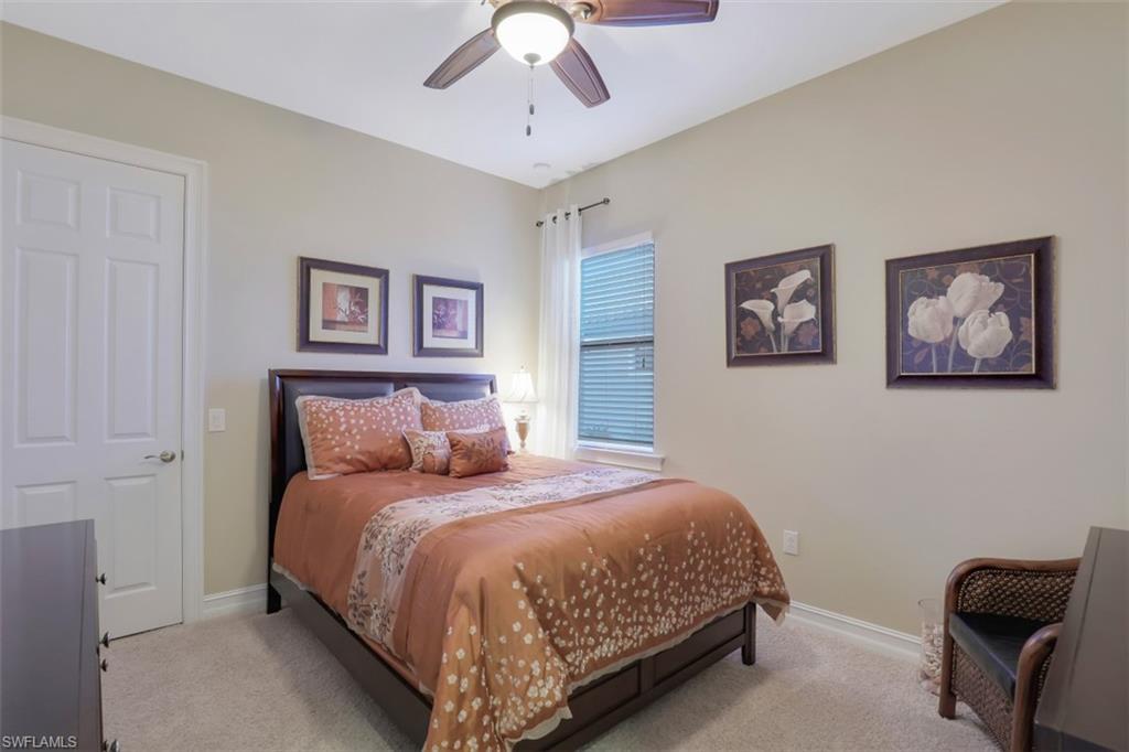 Undisclosed Address Naples, FL 34120 - Photo 17 of 33 a bedroom with a bed and a chandelier