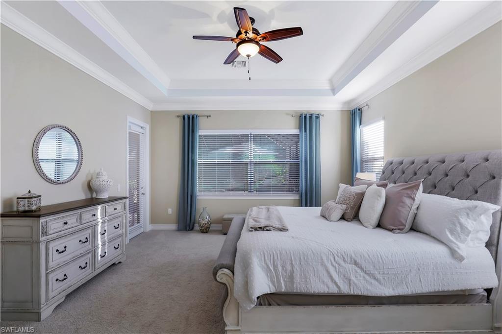 Undisclosed Address Naples, FL 34120 - Photo 32 of 33 a bedroom with a bed a chandelier and a mirror on the dresser