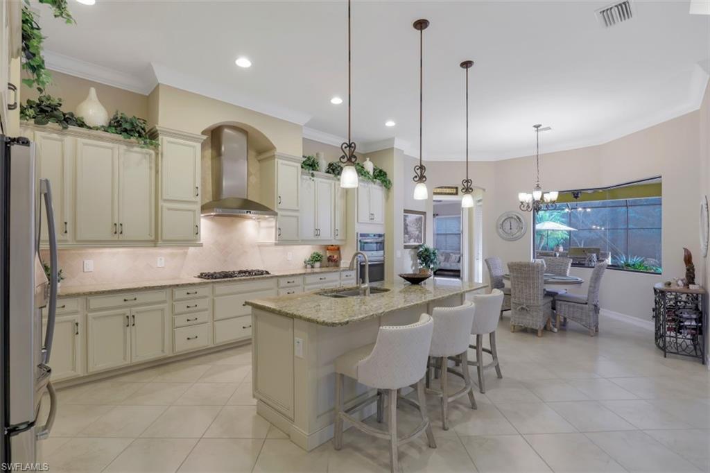 Undisclosed Address Naples, FL 34120 - Photo 5 of 33 a kitchen with center island table and chairs