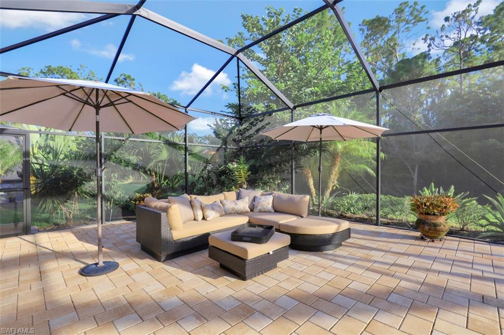 Undisclosed Address Naples, FL 34120 - Photo 6 of 33 a patio with patio a table and chairs under an umbrella