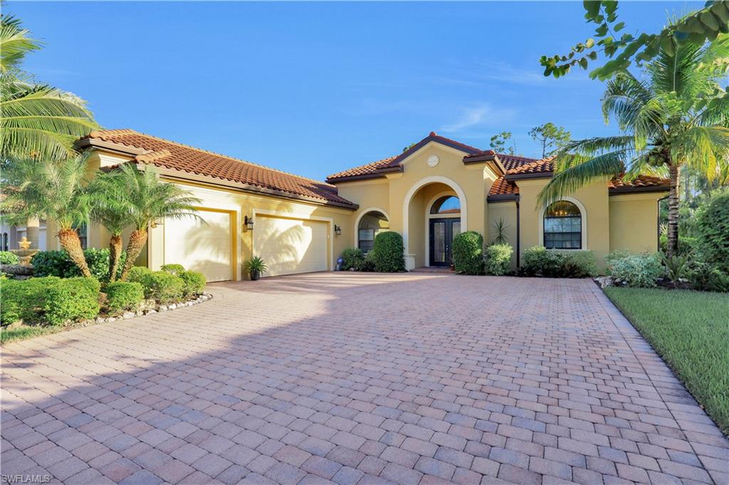 Undisclosed Address Naples, FL 34120 - Photo 7 of 33 a front view of a house with a yard and a garage