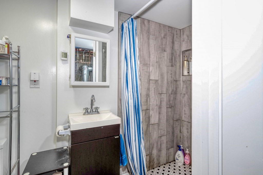 19 Crescent Road Weymouth, MA 02191 - Photo 20 of 24 a bathroom with a sink a mirror a vanity and a shower