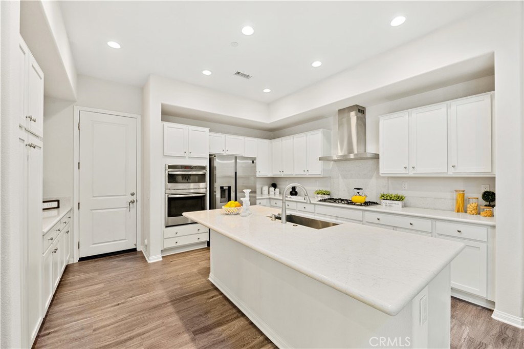 128 Spectacle Irvine, CA 92618 - Photo 3 of 31 a kitchen with white cabinets and white appliances