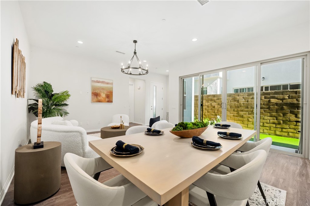 128 Spectacle Irvine, CA 92618 - Photo 4 of 31 a dining room with furniture a large window and a chandelier