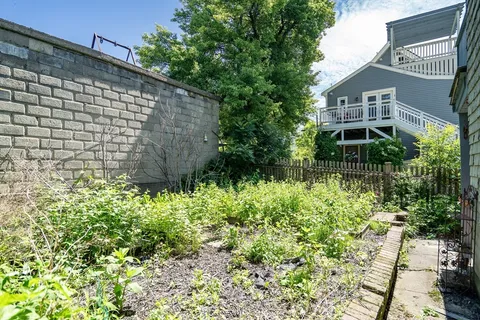 a backyard of a house with a garden and plants