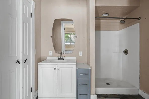 a bathroom with a shower sink and mirror