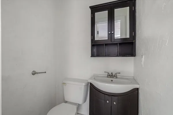 a bathroom with a toilet a sink and mirror
