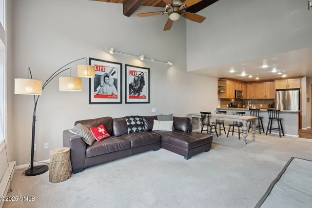 a living room with furniture and kitchen view