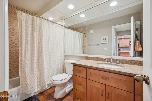 a bathroom with a granite countertop sink toilet and a mirror