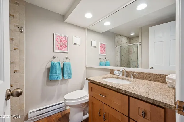 a bathroom with a granite countertop sink a toilet and a mirror