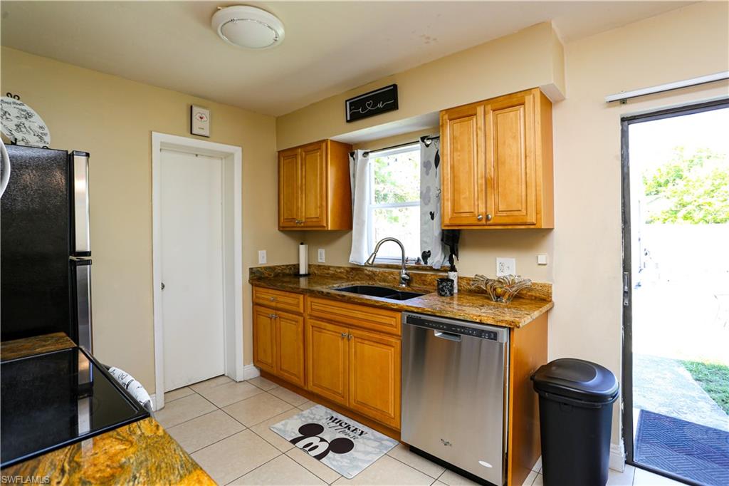 5140 20th Court Southwest Naples, FL 34116 - Photo 11 of 33 a kitchen with stainless steel appliances granite countertop a sink stove and refrigerator