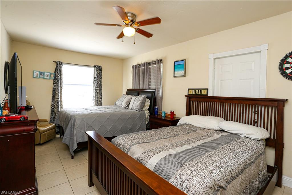 5140 20th Court Southwest Naples, FL 34116 - Photo 19 of 33 a bedroom with a bed and a chandelier