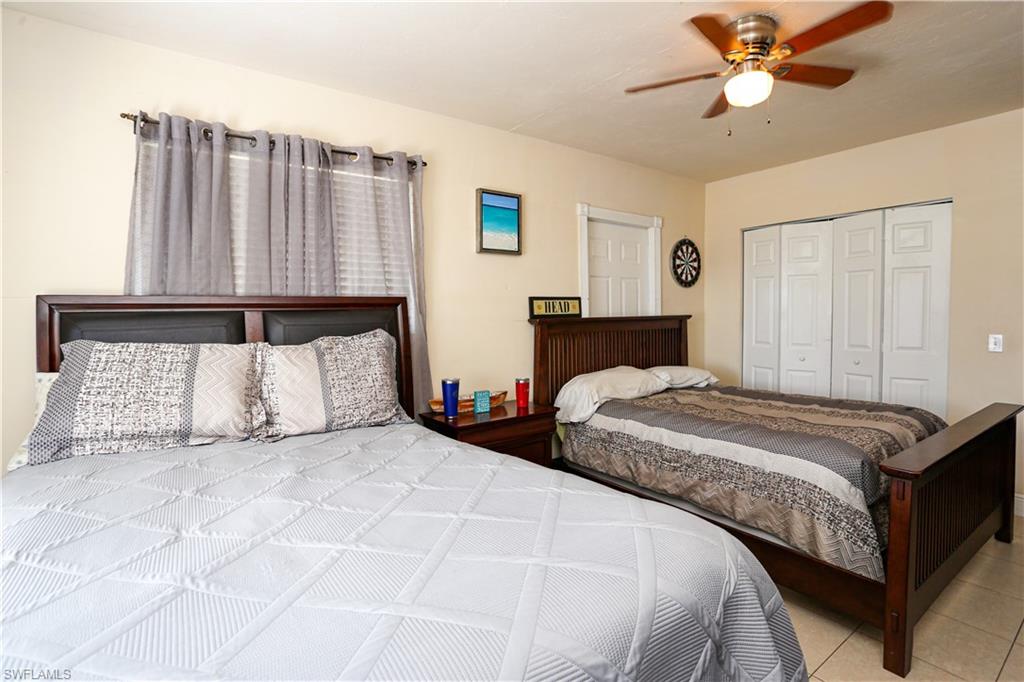 5140 20th Court Southwest Naples, FL 34116 - Photo 20 of 33 a bedroom with a large bed and a ceiling fan