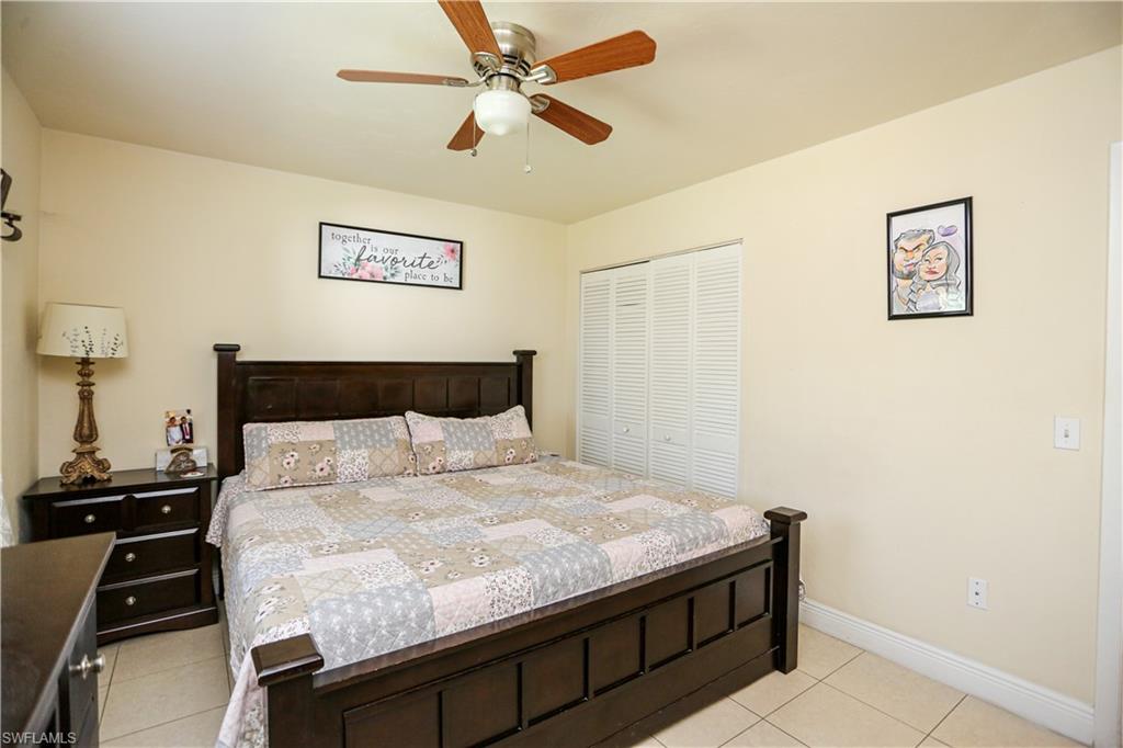 5140 20th Court Southwest Naples, FL 34116 - Photo 23 of 33 a bedroom with a bed and a chandelier