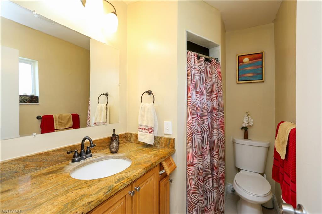 5140 20th Court Southwest Naples, FL 34116 - Photo 24 of 33 a bathroom with a granite countertop toilet sink and mirror