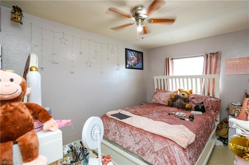 5140 20th Court Southwest Naples, FL 34116 - Photo 25 of 33 a bedroom with a bed and a chandelier
