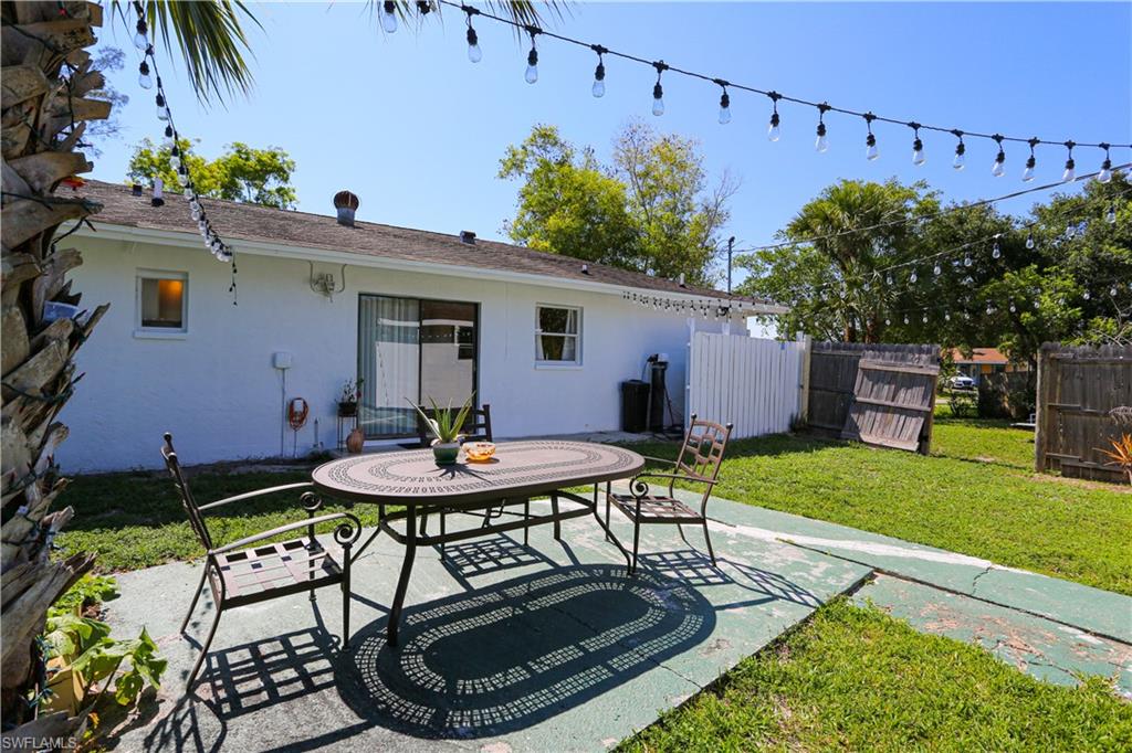 5140 20th Court Southwest Naples, FL 34116 - Photo 28 of 33 a backyard of a house with table and chairs plants and large tree