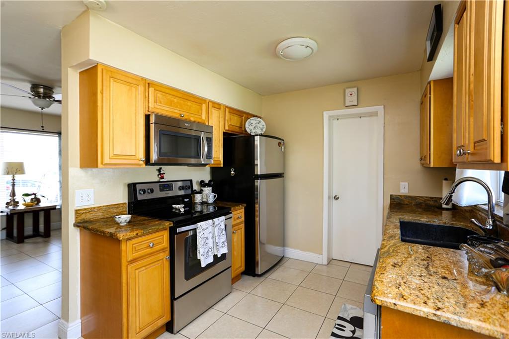 5140 20th Court Southwest Naples, FL 34116 - Photo 10 of 33 a kitchen with stainless steel appliances granite countertop a stove a sink and a microwave