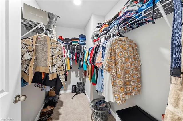 a view of walk in closet with clothes and shoes
