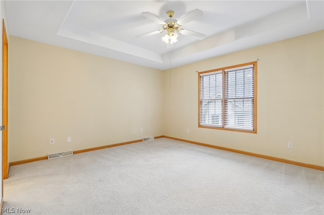 7007 Clingan Road, Unit 85 Youngstown, OH 44514 - Photo 29 of 46 Tray ceiling with recessed lighting, ceiling fan, carpeting, and wood-trim window