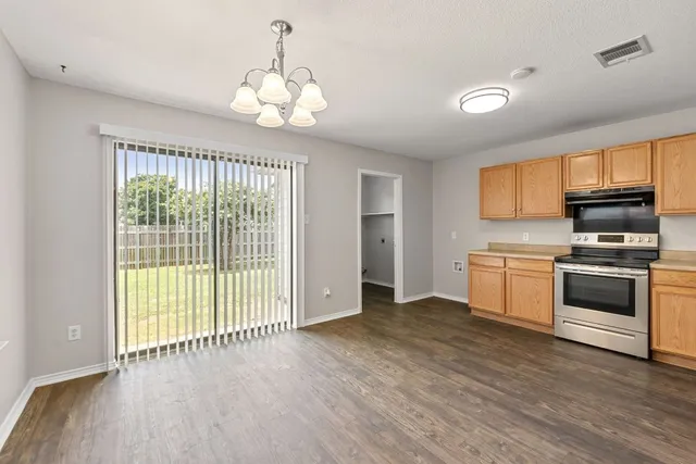 a kitchen with wooden floors and stainless steel appliances