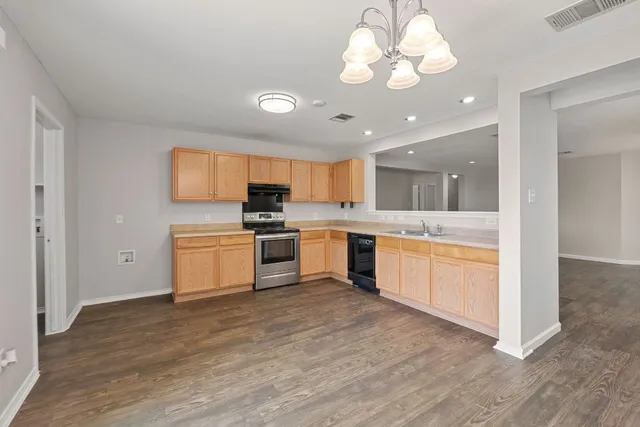 a open kitchen with a refrigerator and white cabinets
