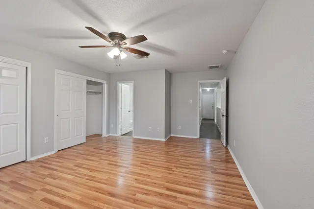 a view of empty room with wooden floor