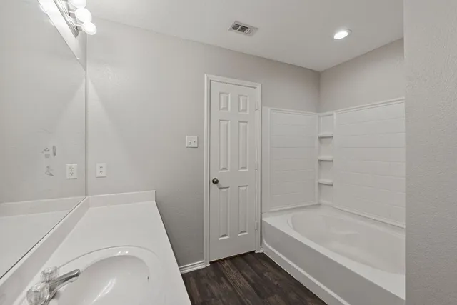a bathroom with a tub a sink and a shower