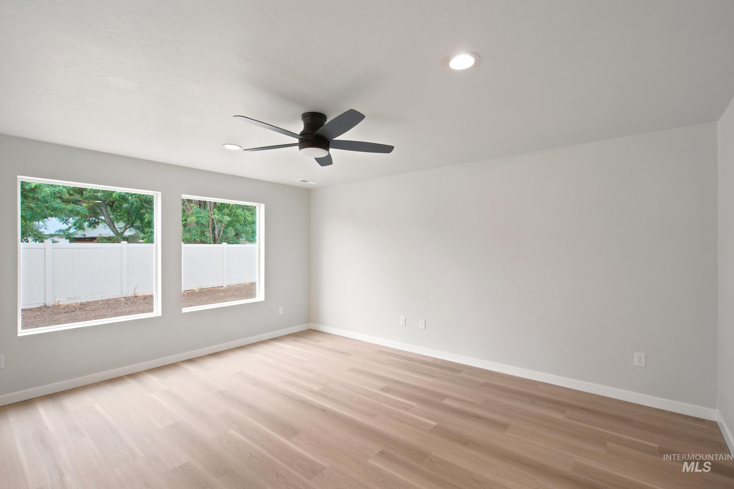 472 Merlin Court Middleton, ID 83644 - Photo 10 of 25 Neutral wall paint, wood-finish flooring, white window trim, and a ceiling-mounted light fixture