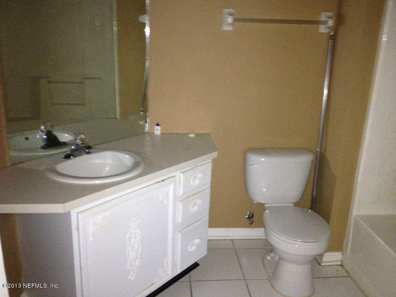 7990 Baymeadows Road East, Unit 426 Jacksonville, FL 32256 - Photo 13 of 14 a bathroom with a granite countertop toilet sink and mirror