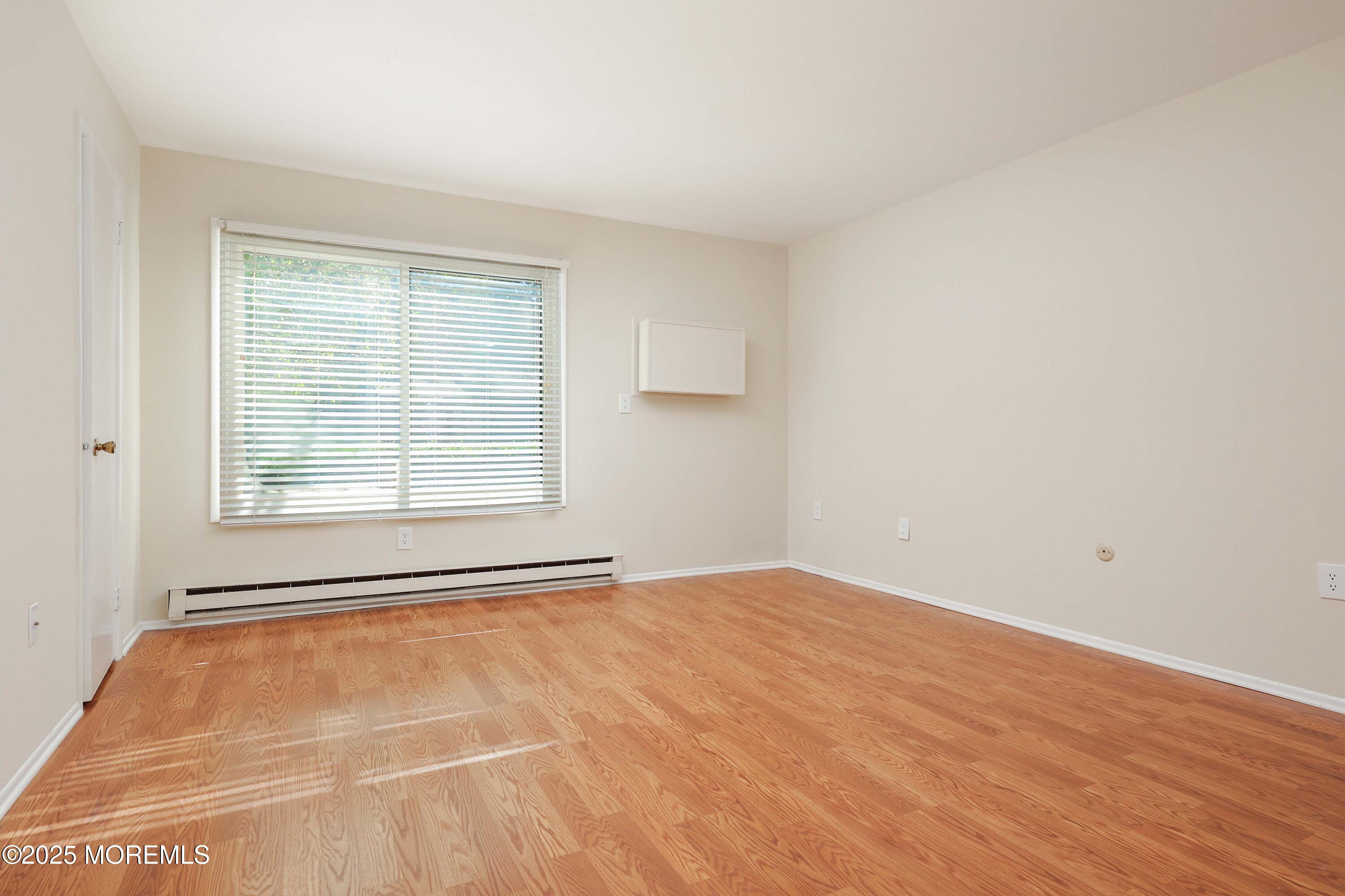 109 Lexington Court Red Bank, NJ 07701 - Photo 29 of 62 a view of an empty room with wooden floor and a window