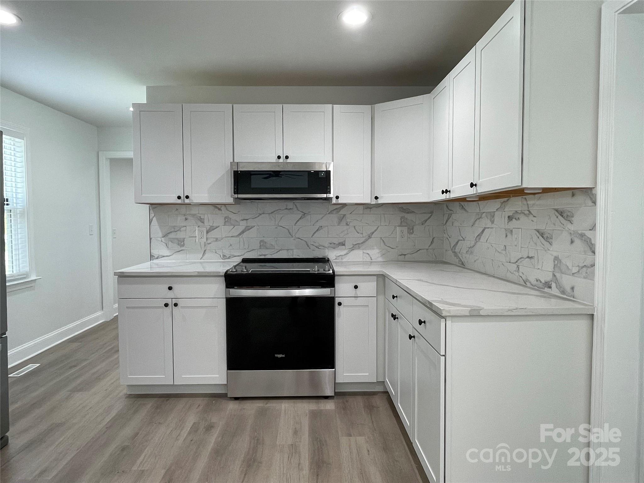 210 River Drive Gaffney, SC 29340 - Photo 8 of 18 a kitchen with stainless steel appliances granite countertop a stove a sink and white cabinets