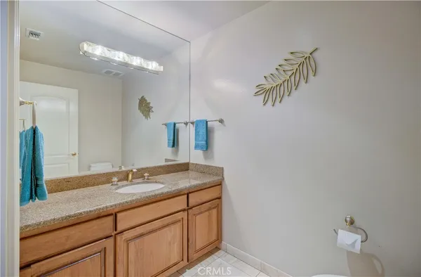 a bathroom with a granite countertop sink a mirror and vanity