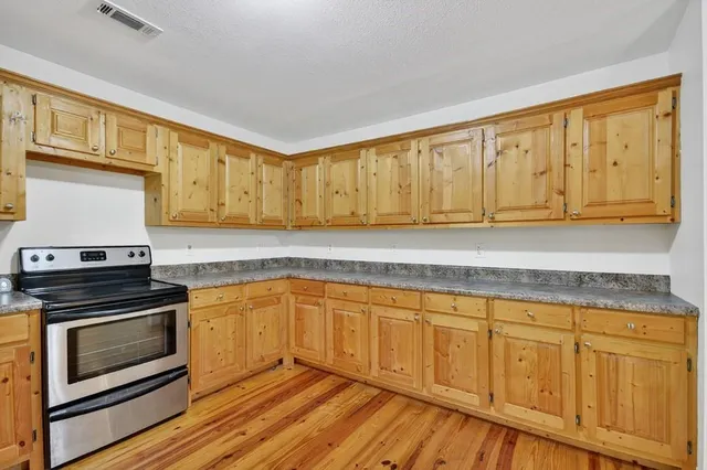 a kitchen with wooden cabinets and a stove top oven