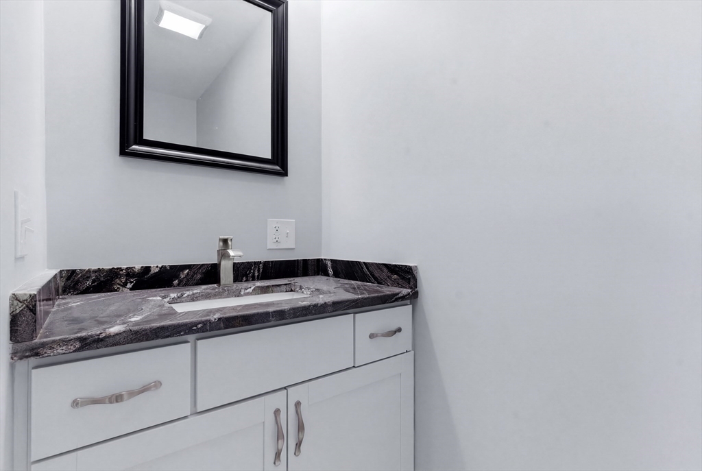 10 North Court Street, Unit 3 Fall River, MA 02720 - Photo 20 of 25 a bathroom with a granite countertop sink and mirror