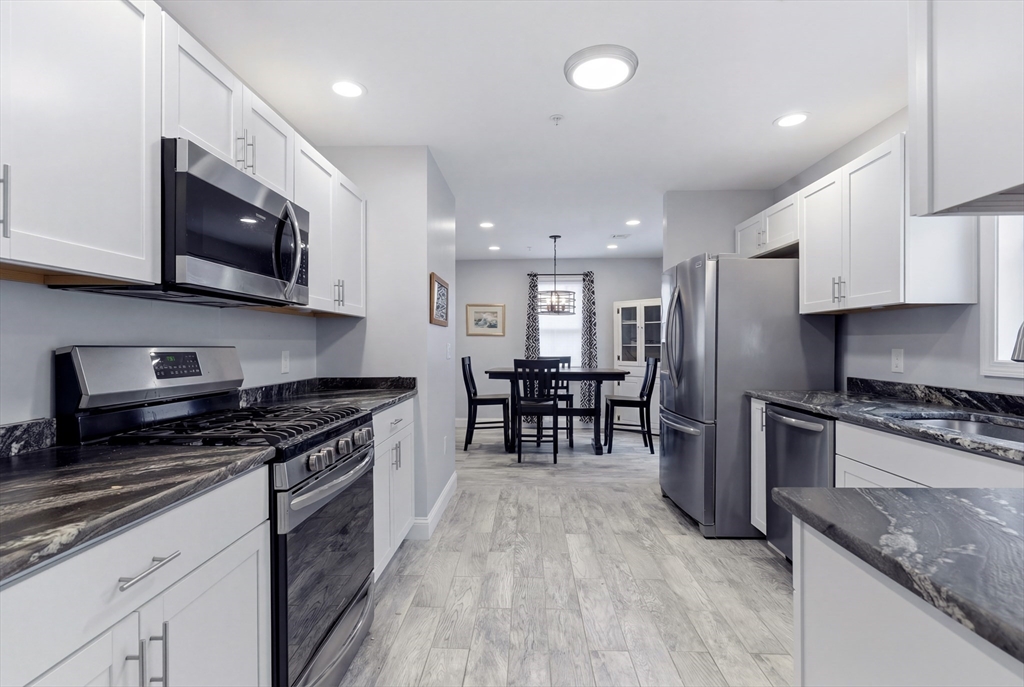 10 North Court Street, Unit 3 Fall River, MA 02720 - Photo 3 of 25 a kitchen with stainless steel appliances granite countertop wooden cabinets a stove top oven a sink and dishwasher