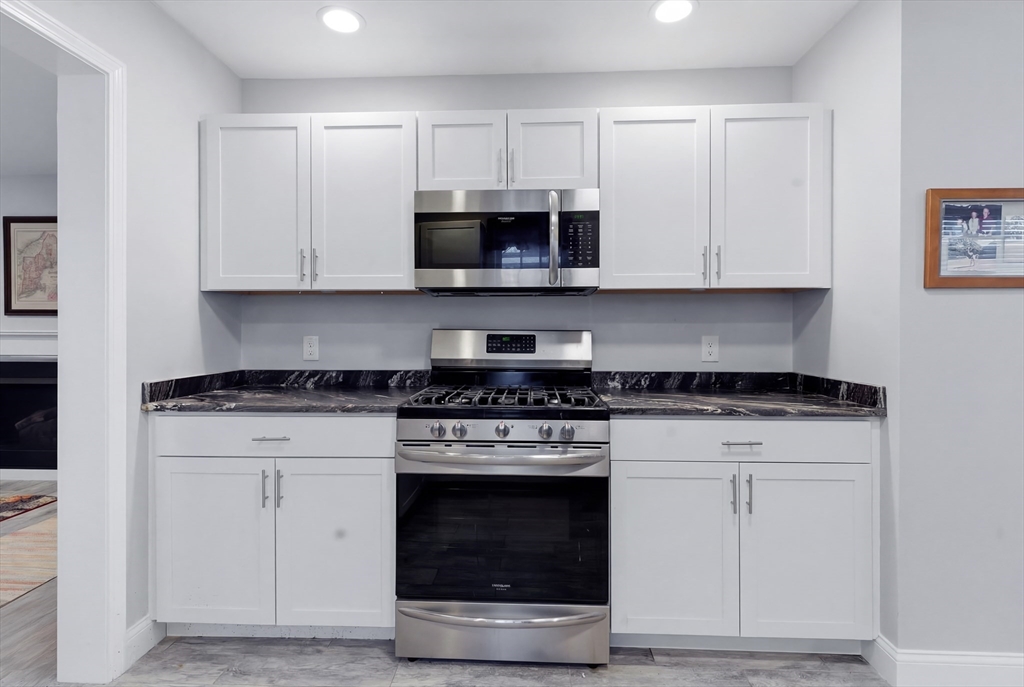 10 North Court Street, Unit 3 Fall River, MA 02720 - Photo 4 of 25 a kitchen with granite countertop white cabinets and stainless steel appliances