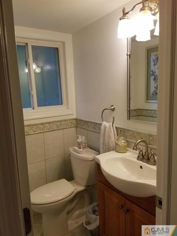21 Barker Road Somerset, NJ 08873 - Photo 5 of 25 a bathroom with a toilet sink and mirror