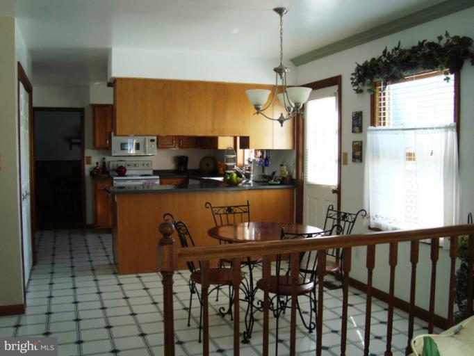 8166 N Road Severn, MD 21144 - Photo 13 of 25 a kitchen with stainless steel appliances granite countertop a sink a stove and a refrigerator