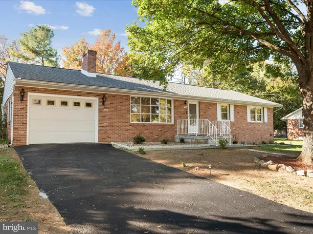 a view of a house with a yard and large tree